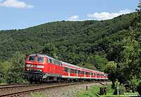 Nahe Mürlenbach eilt die 218 217 mit dem RE 12083 durch das schmale und kurvenreiche Kylltal. 4.8.2009