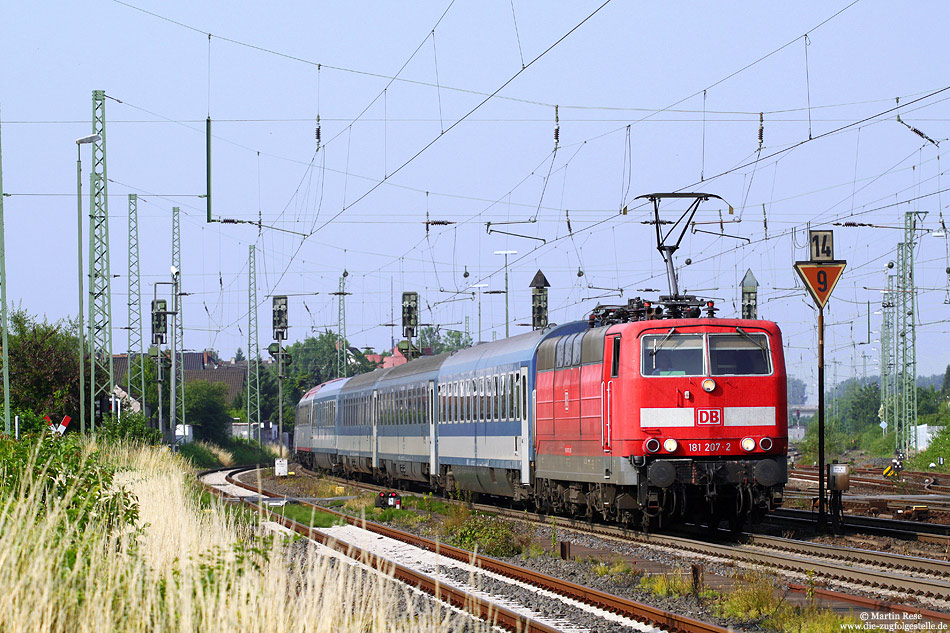 181 207 in verkehrsrot mit EN408 auf der Riedbahn im Bahnhof Biblis