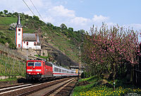 181 212 in verkehrsrot auf der Moselstrecke in Hatzenport mit Kapelle