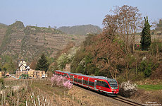 643 011 im frühlingshaften Ahrtal bei Mayschoß mit Bahnhof im Hintergrund