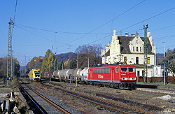 Energiecontainer 155 143 in verkehrsrot mit Güterzug im Bahnhof Schladern