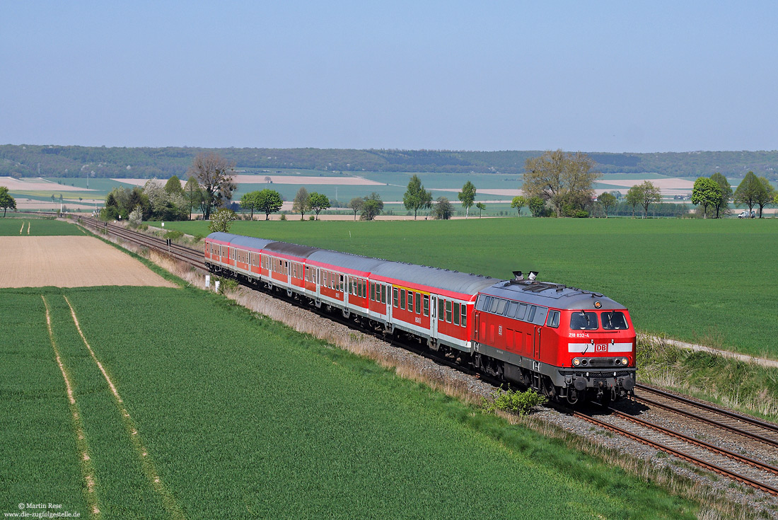 Abschlepplokomotive 218 822 in verkehrsrot mit Regionalexpress im Vorharz bei Baddeckenstedt