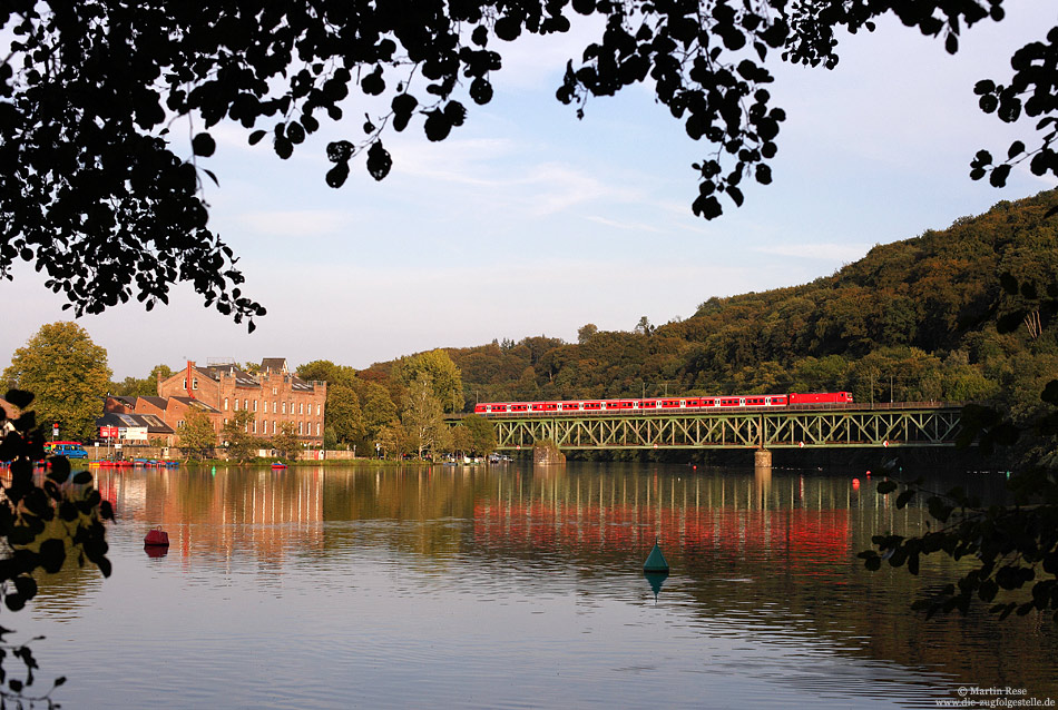 Von wegen Kohlenpott: Zwischen Essen und Düsseldorf verläuft die S6 auf einer landschaftlich recht reizvollen Strecke. Das fotografische Highlight dürfte wohl die Brücke über den Ruhrstausee bei Kettwig sein. Am Abend des 2.9.2011 poltert die 143 292 mit der S6 nach Köln Nippes über die Brücke.