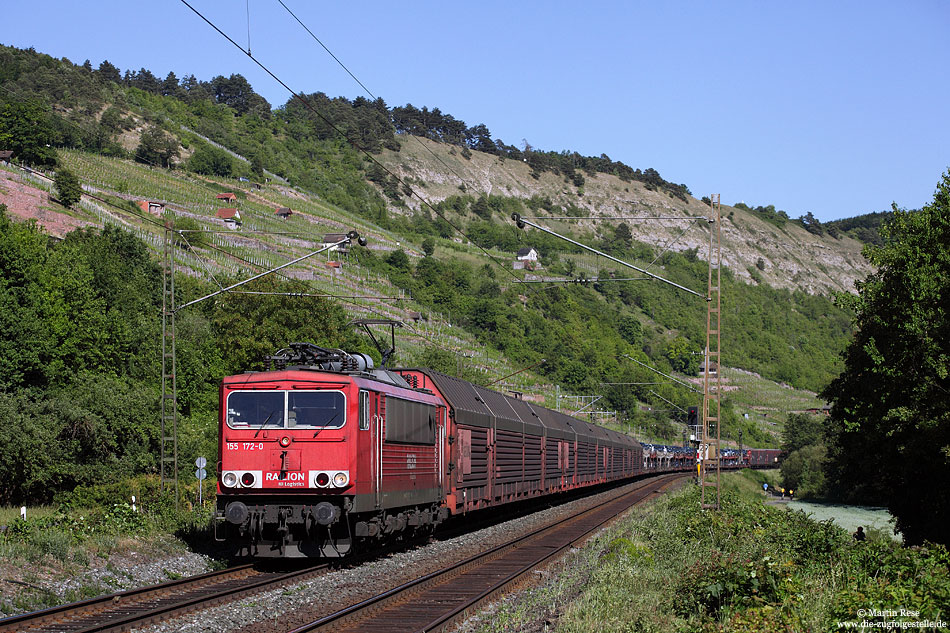 Am ehemaligen Haltepunkt Gambach rollt die 155 172 mit einer Ladung nagelneuer „Daimler-Benz“ durch das Maintal. 25.5.2011
