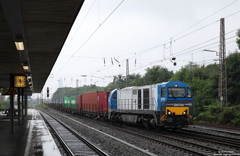Bei typischen „Juli 2012-Wetter“ passiert die DH754 der HGK mit einem Containerzug die S-Bahnstation Köln Geldernstraße Parkgürtel. 15.7.2012
