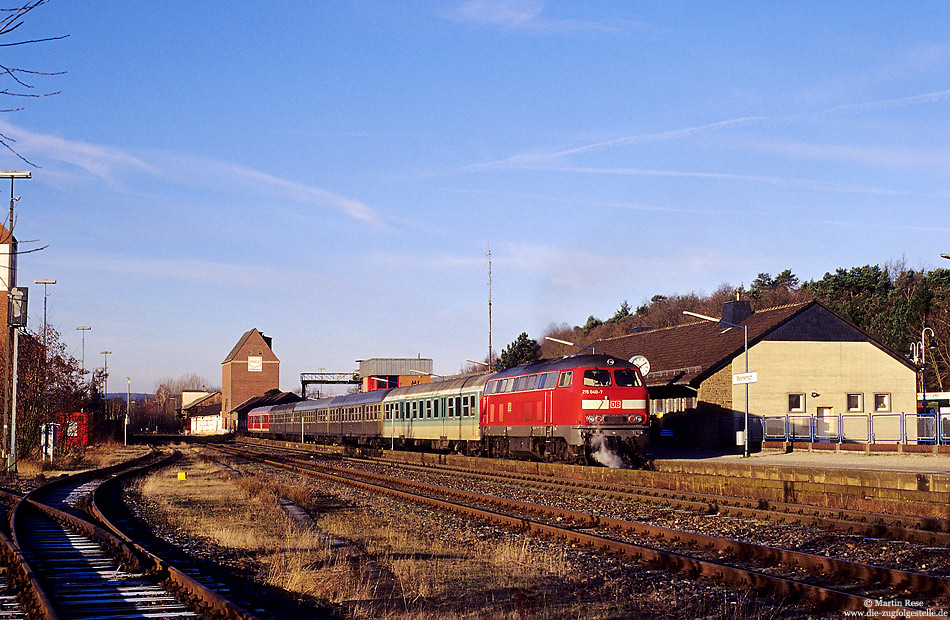 215 040 in verkehrsrot mit RE im Bahnhof Mechernich