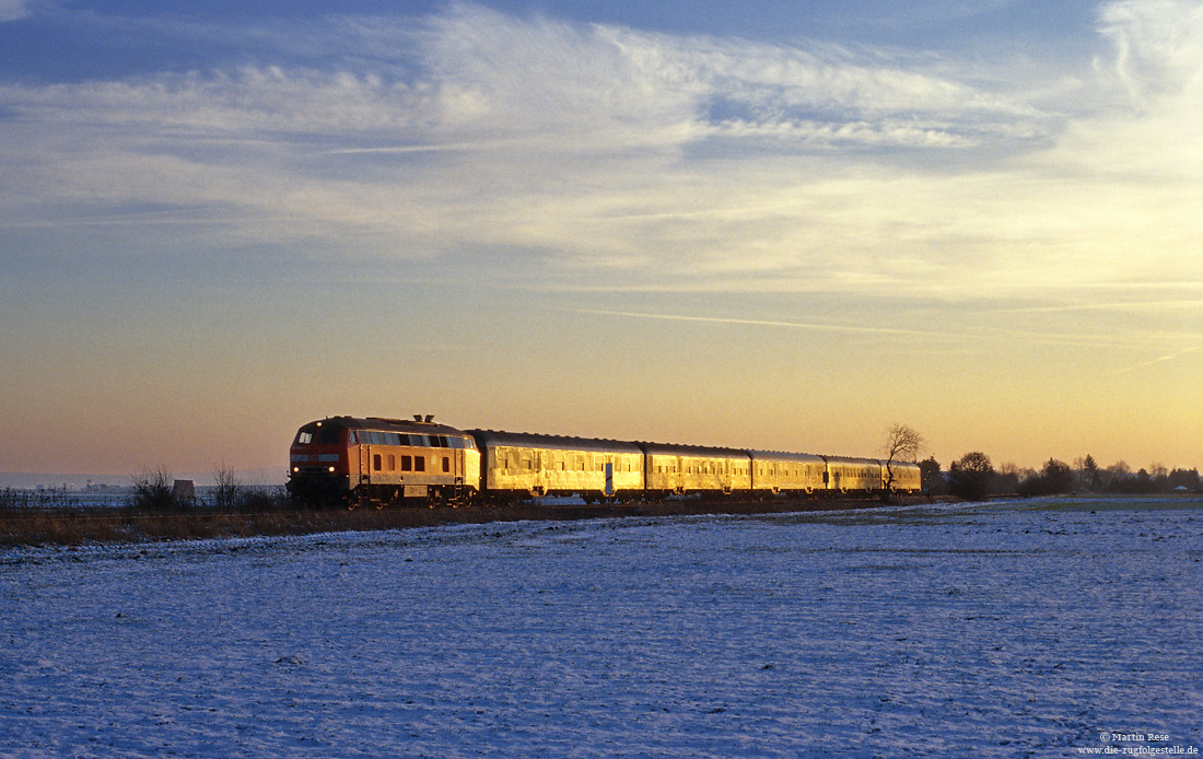 Die untergehende Sonne des 9.1.2003 lässt den RE 22084 im goldenen Licht leuchten.