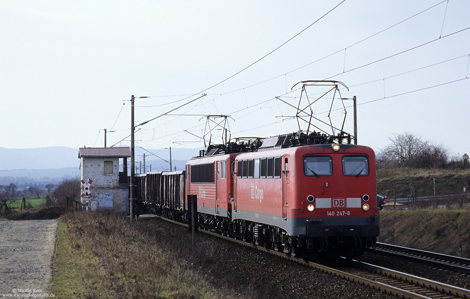 Nachdem die Schiebelokomotive in Sangerhausen eingespart wurde, mussten schwere Güterzüge fortan in Doppeltraktion oder mit Vorspann gefahren werden. Westlich von Sangerhausen leistet die 140 247 der 155 104 Vorspann. 6.2.2004