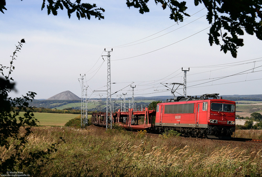 Mit einem Güterzug gen Osten erklimmt die 155 181 die Rampe zwischen Sangerhausen und Riestedt. Im Hintergrund ist die Abraumhalde des stillgelegten Thomas-Müntzer-Schachtes in Sangerhausen zu sehen. 21.9.2007