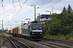 185 556 mit Warsteiner-Zug im Bahnhof Warburg mit Stellwerk