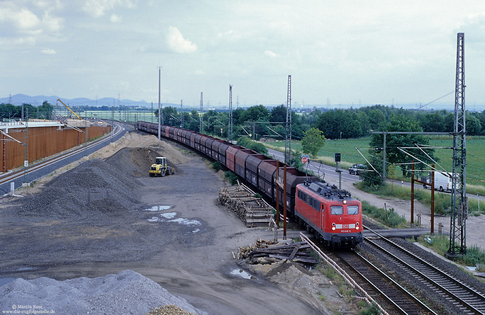 Von einer provisorischen, dem Baustellenverkehr dienenden Überführung, habe ich am 6.6.2002 in Porz Wahn die 140 446 mit einem leeren Kohlezug fotografiert. Das Bild des Bahnhofs hatte sich gegenüber der vorherigen Aufnahme schon stark verändert!