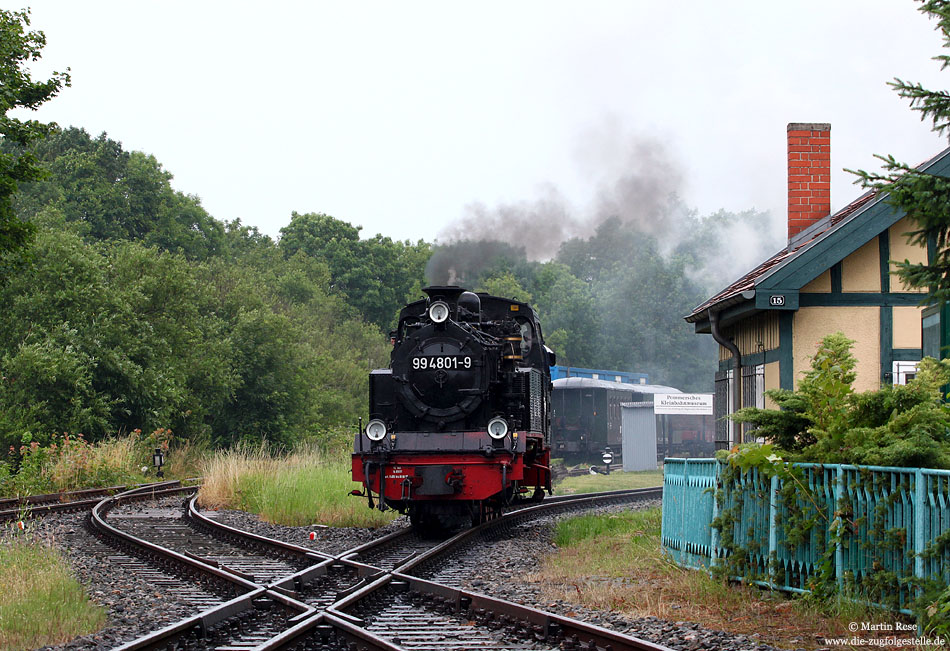 Am verregneten 10.7.2009 rangiert die 99 4801 im Bahnhof Putbus. Im Vordergrund kreuzen sich Schmalspur- und Regelspurgleis.