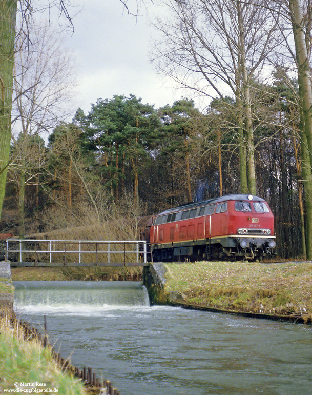 216 157 in rot auf dem Anschlußgleis Benteler-Talle mit Lippe im Vordergrund